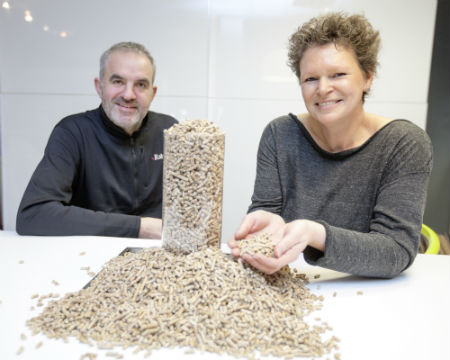 Michael and Kate Wright of Yorkshire Heat Pumps with a pile of biomass pellets